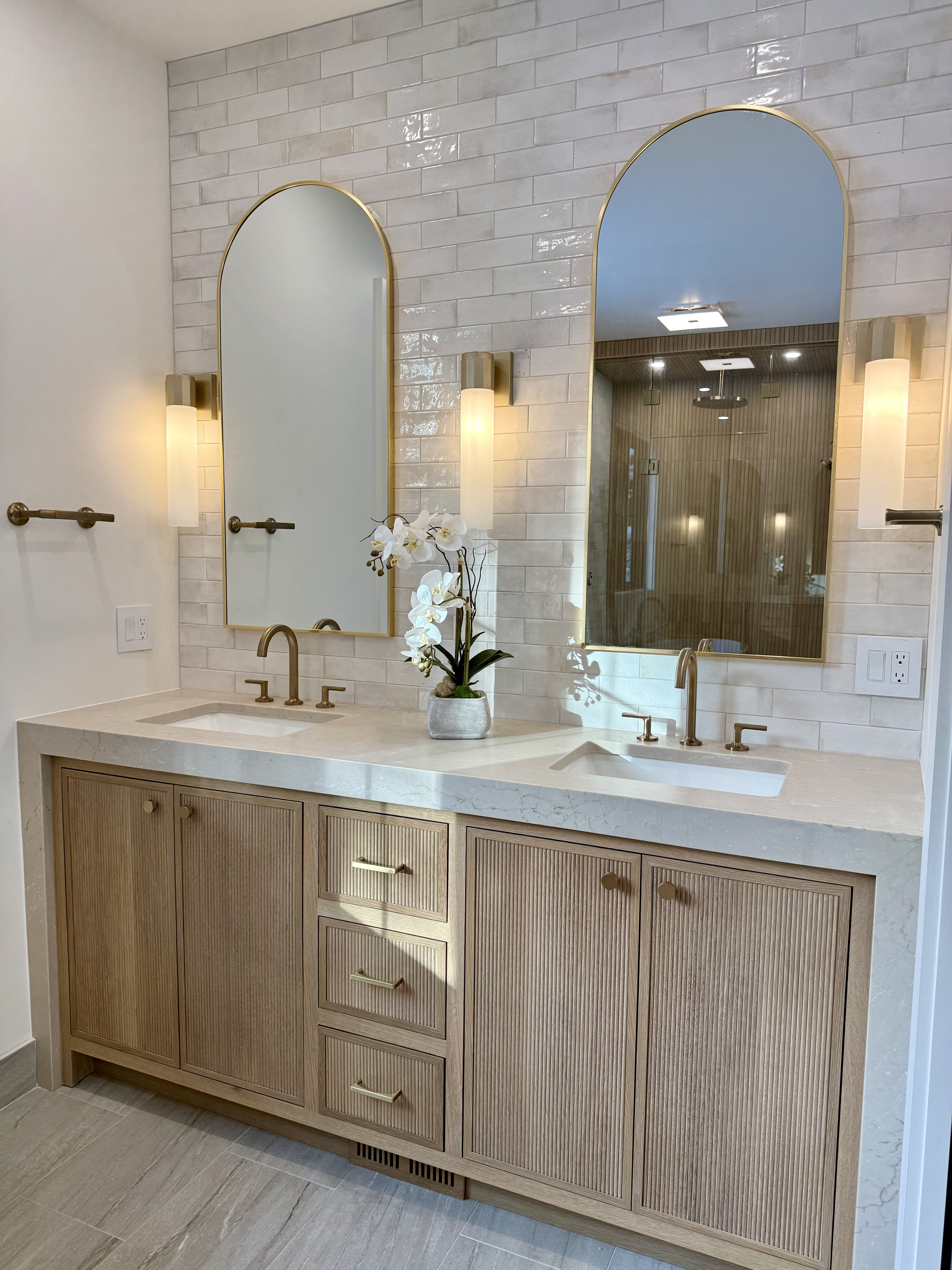 Bath with brass arched mirrors