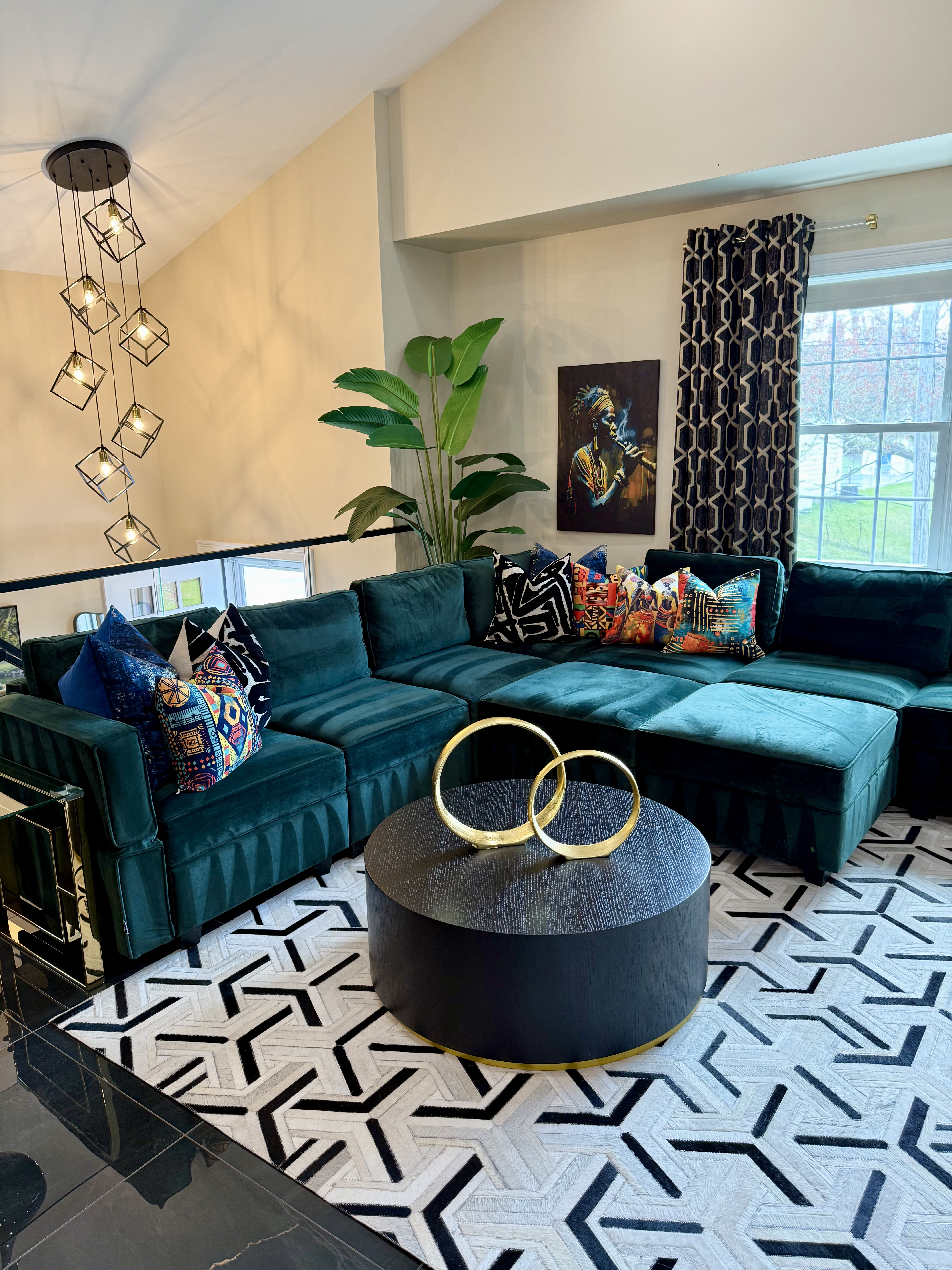 A bold living room with teal sectional, patterned rug, and African art